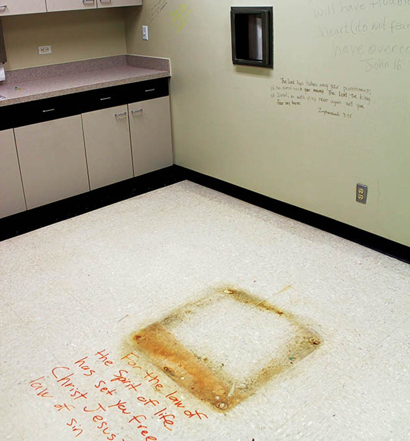 Former abortion procedure room where pro-life advocates have inscribed the walls and floor with Scripture. The floor stain marks the location of the surgical table and the steel carousel in the wall transferred the aborted fetus to the biohazard waste.